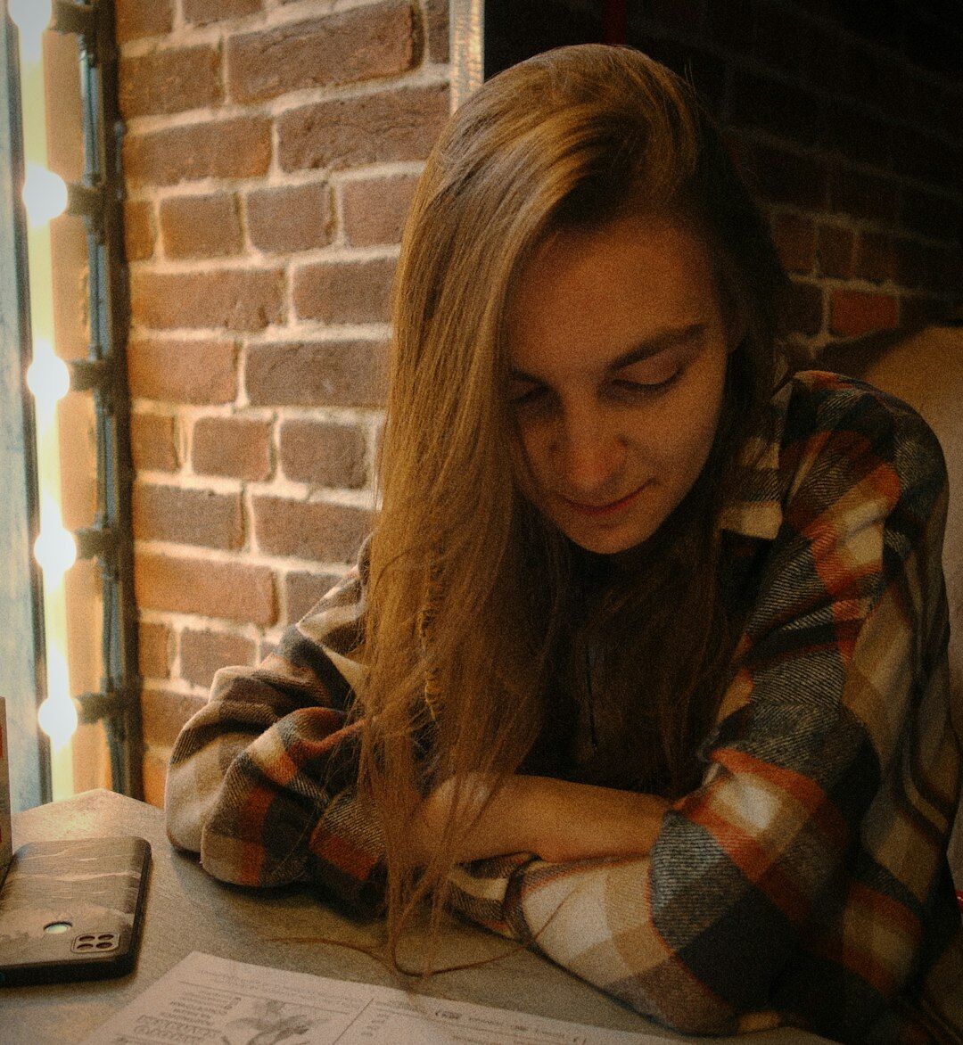 Young woman reflecting while writing in a personal development journal