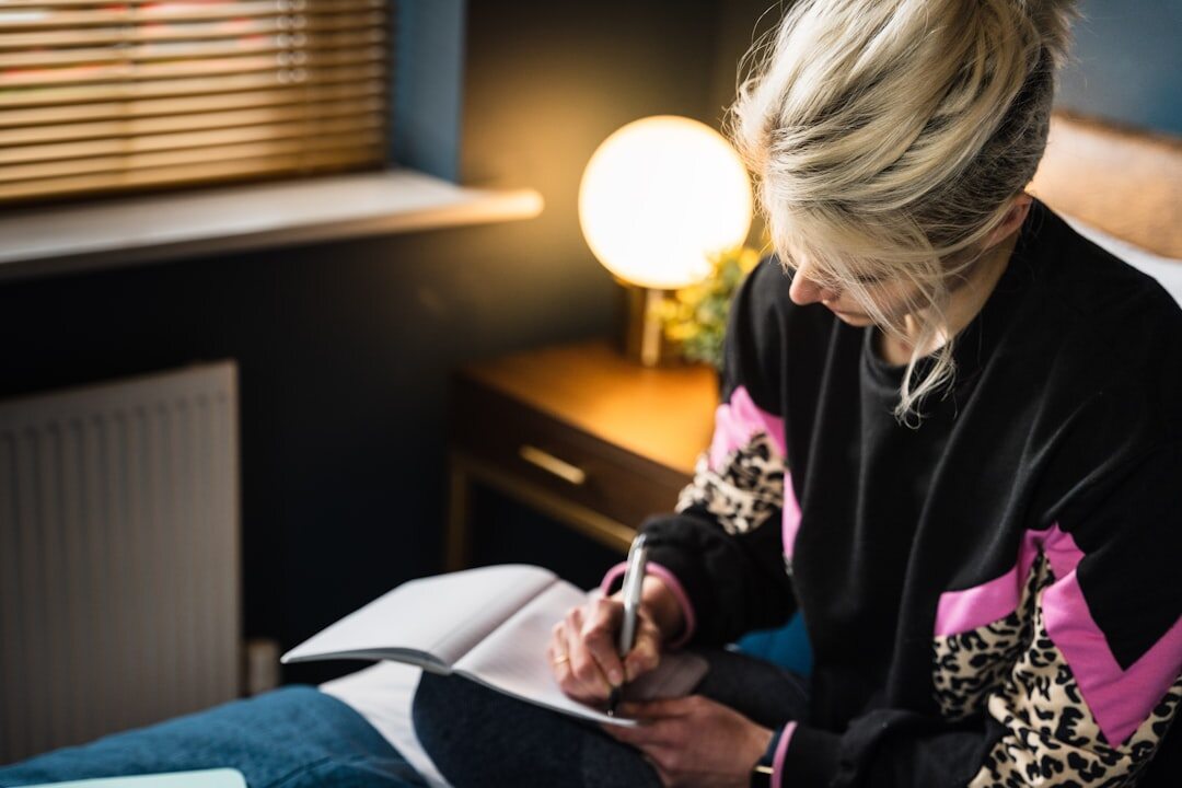 person writing in journal